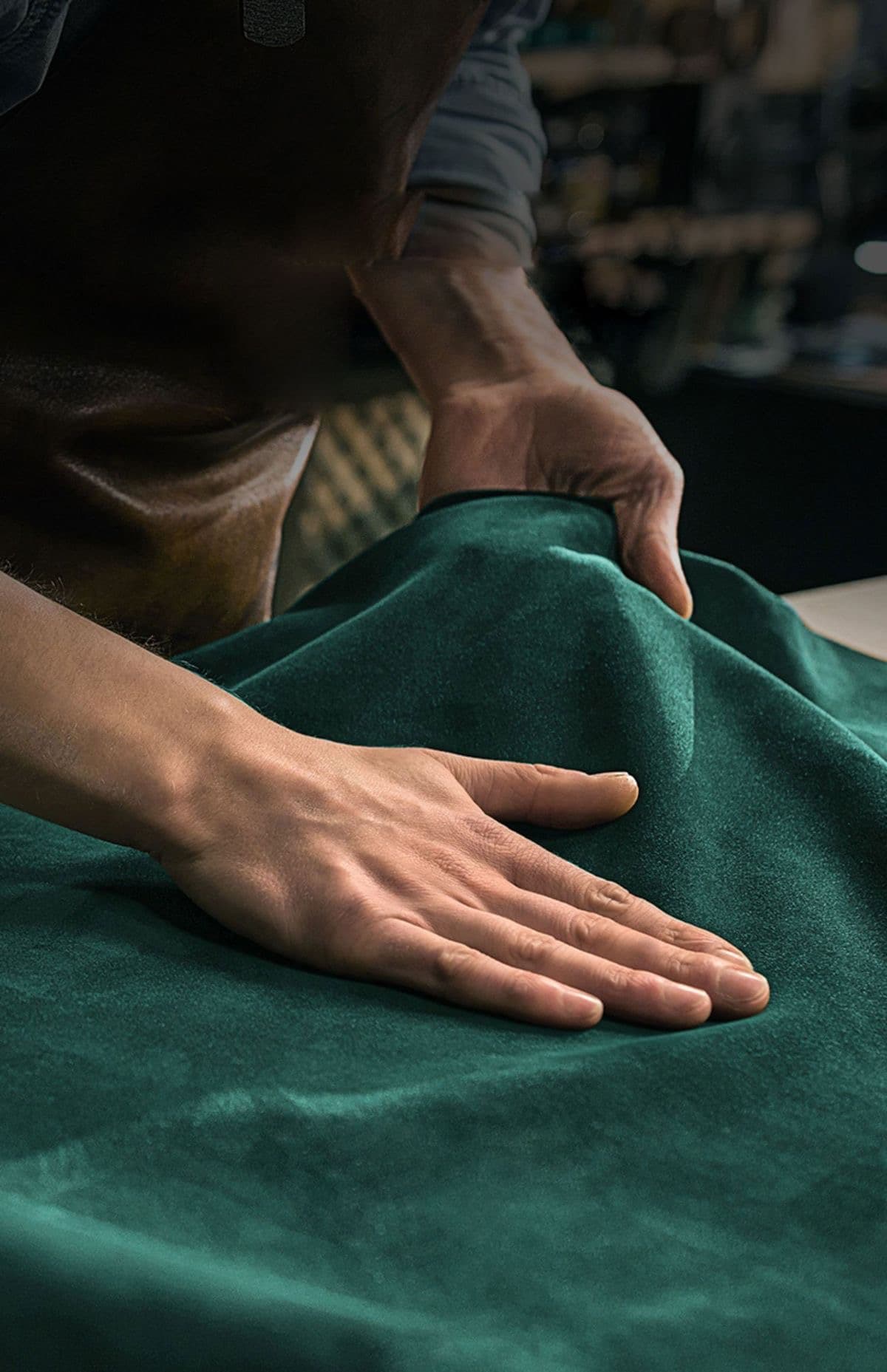 Hands smoothing leather in development.