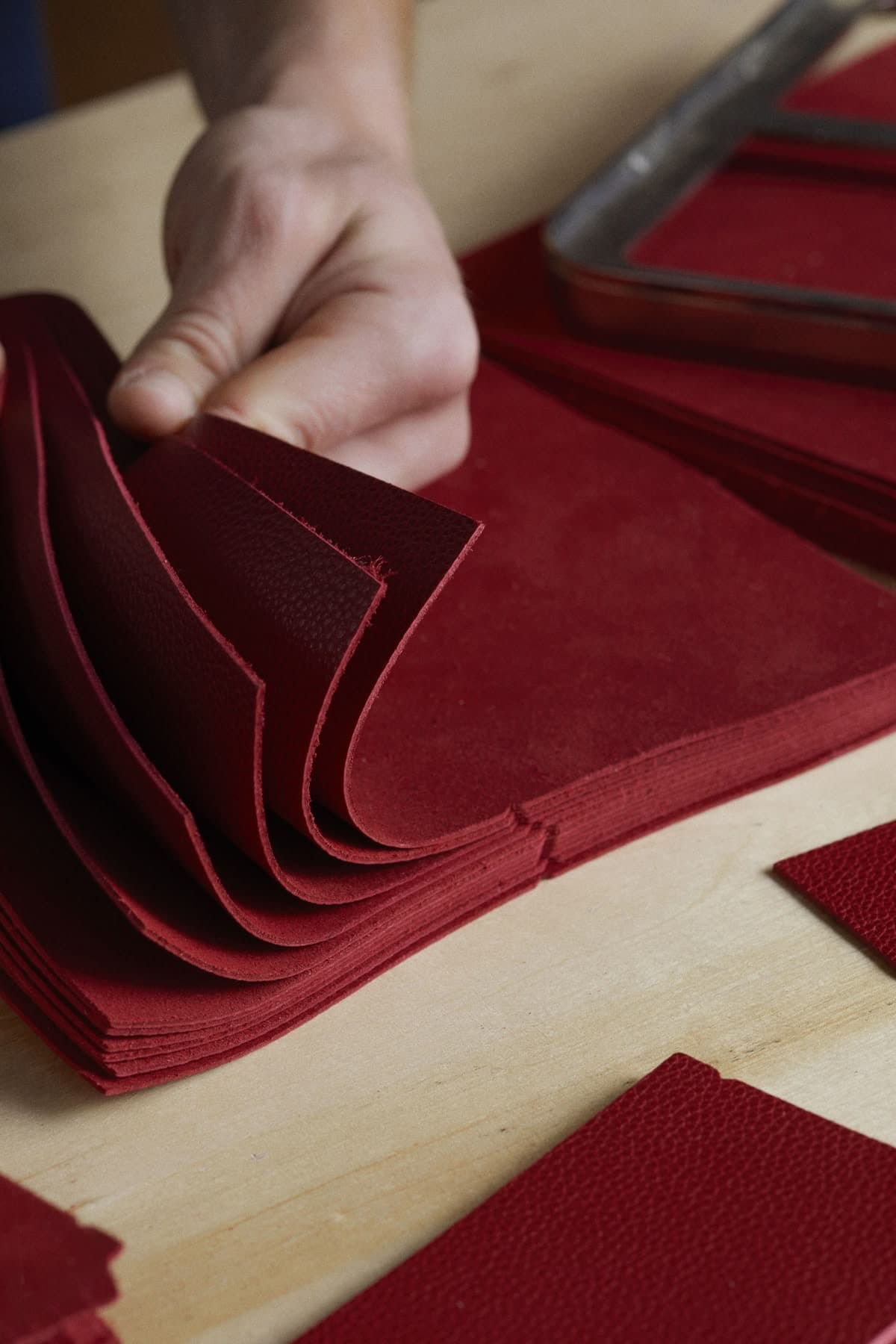 Leather articles arranged across a cutting table.